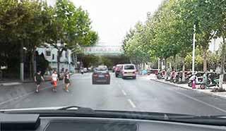 在混合交通的街道上行车，遇到年轻人准备横穿道路时（如图所示），教练员应提示学员___。 